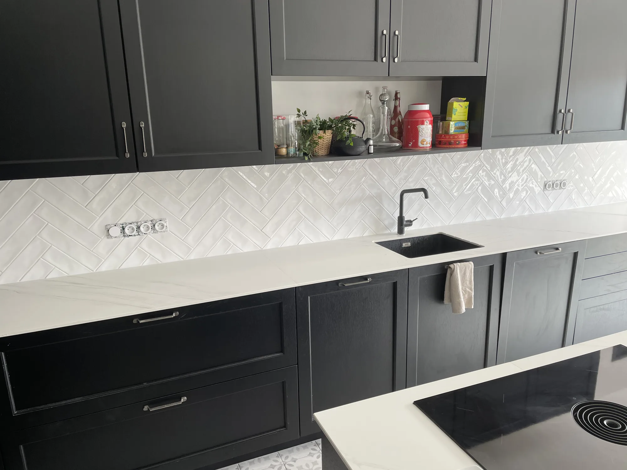 Credence de cuisine en faience blanche brillante posee en chevrons, chantier de carrelage realise en Vendee
